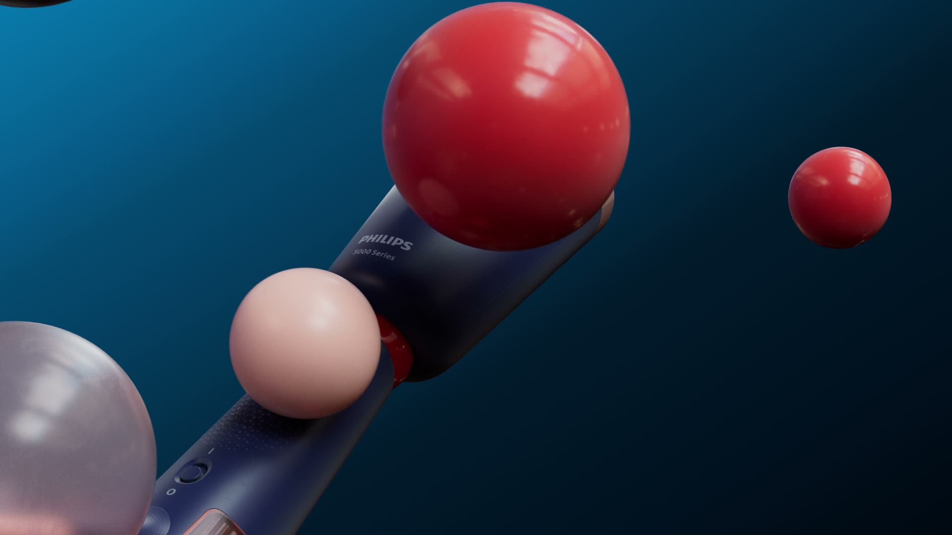 De handstomer schuin in beeld tussen rode en roze bollen.